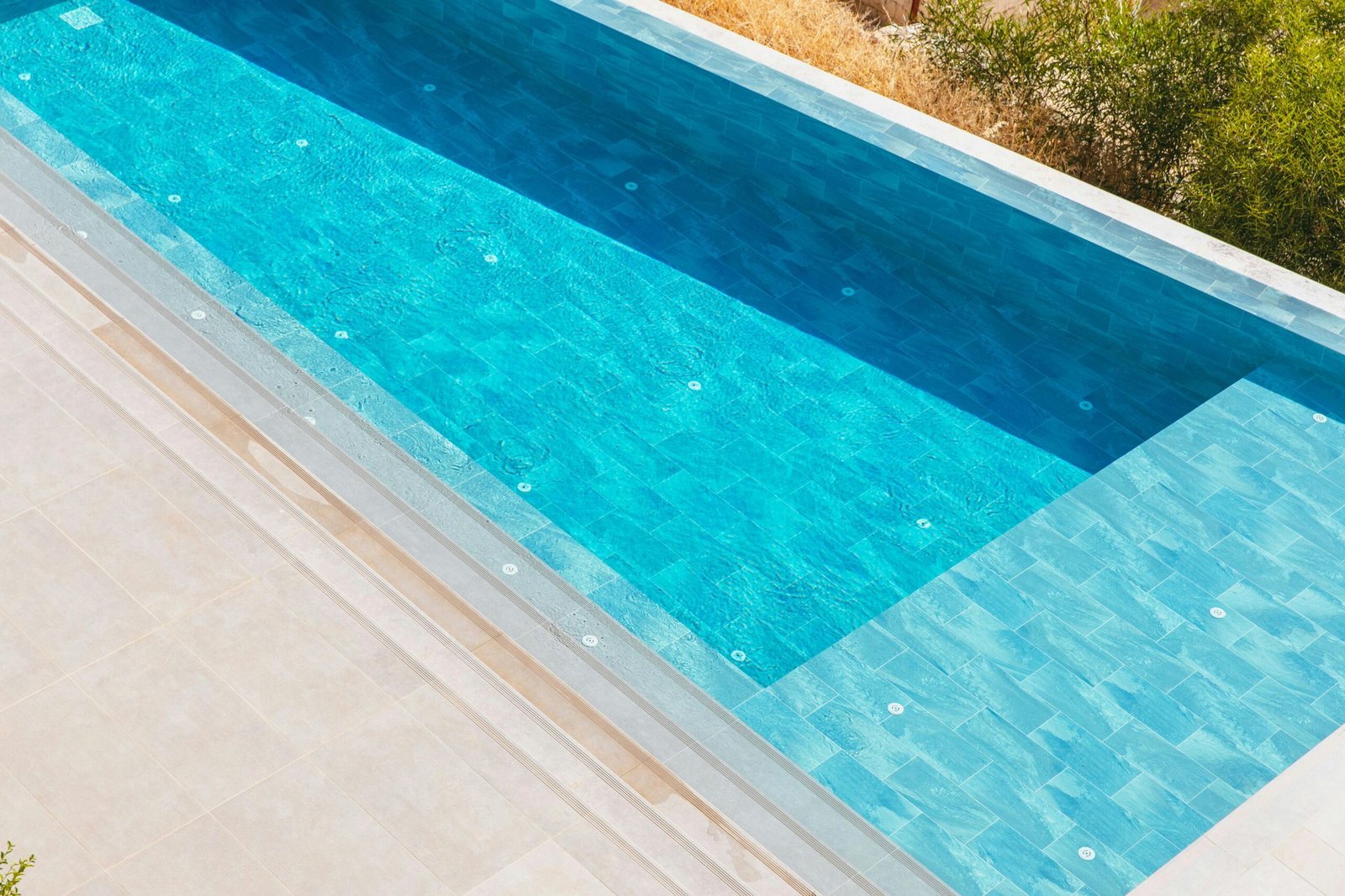 Elegant aerial view of a luxurious swimming pool surrounded by a serene deck. Perfect for summer themes.